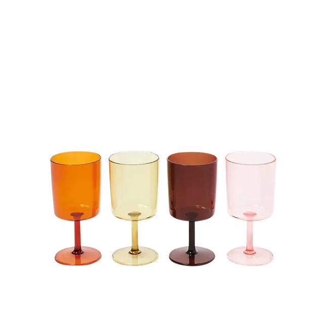 Four colorful wine glasses in orange, yellow, brown, and pink, lined up against a white background.