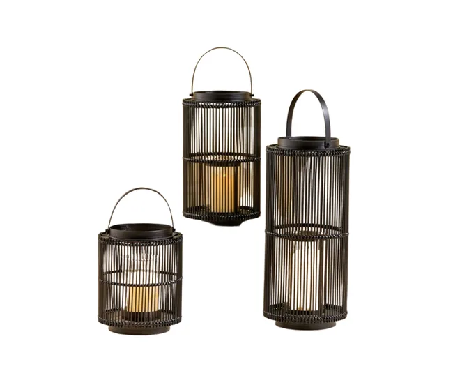 Three metal lanterns with cylindrical shapes, each holding a lit candle inside, varying in size.