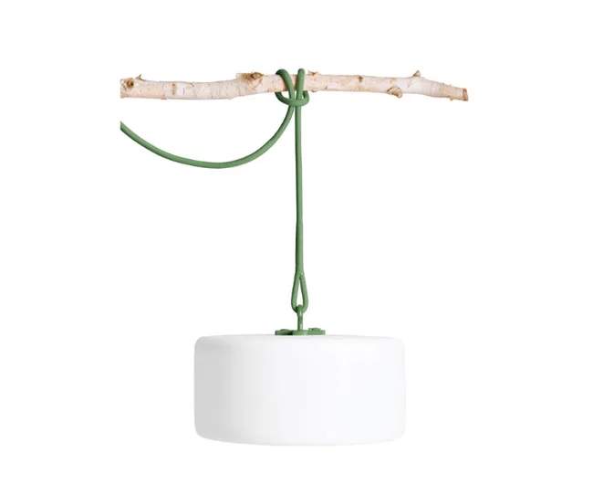 Hanging lamp with a white cylindrical shade and green cord tied to a wooden branch.