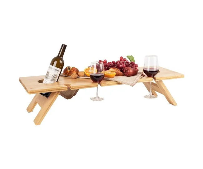 Picnic table with wine bottle, two glasses of red wine, fruits, and bread on a portable wooden stand.