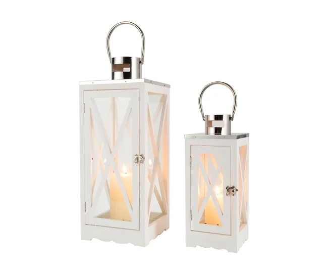 White lanterns with glass panels and metal handles, one large and one small, each containing a lit candle inside.