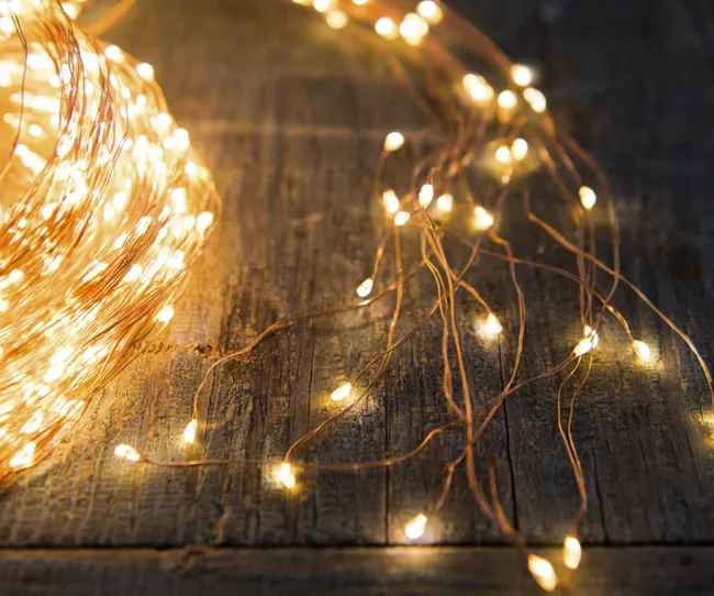 Warm fairy lights on a rustic wooden surface, creating a cozy and ambient atmosphere.