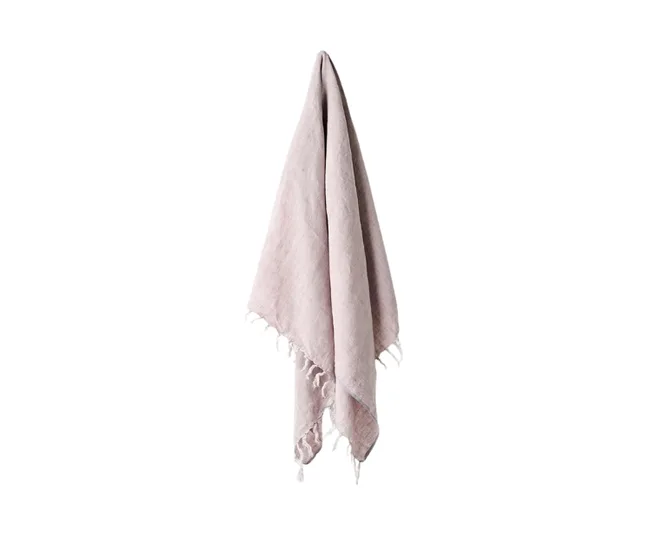 Beige towel with tassels hanging against a white background.