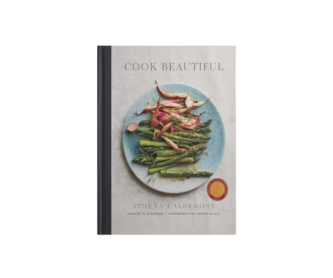 Cookbook cover titled "Cook Beautiful" by Athena Calderone, featuring asparagus and radishes on a blue plate.