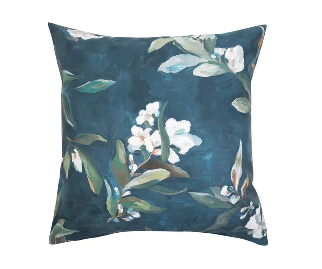 Floral-patterned cushion with white flowers and green leaves on a dark blue background.