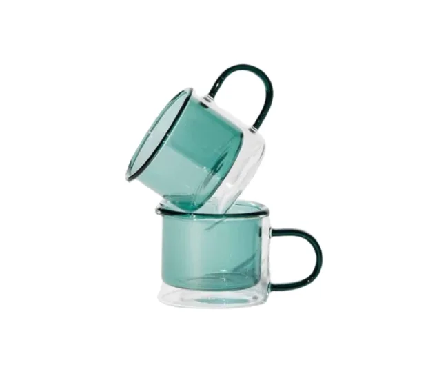 Two stacked clear green glass mugs with handles on a white background.