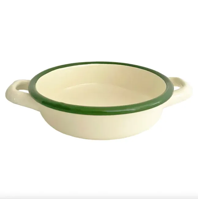 Cream enamel baking dish with green rim and handles, viewed from an angle.