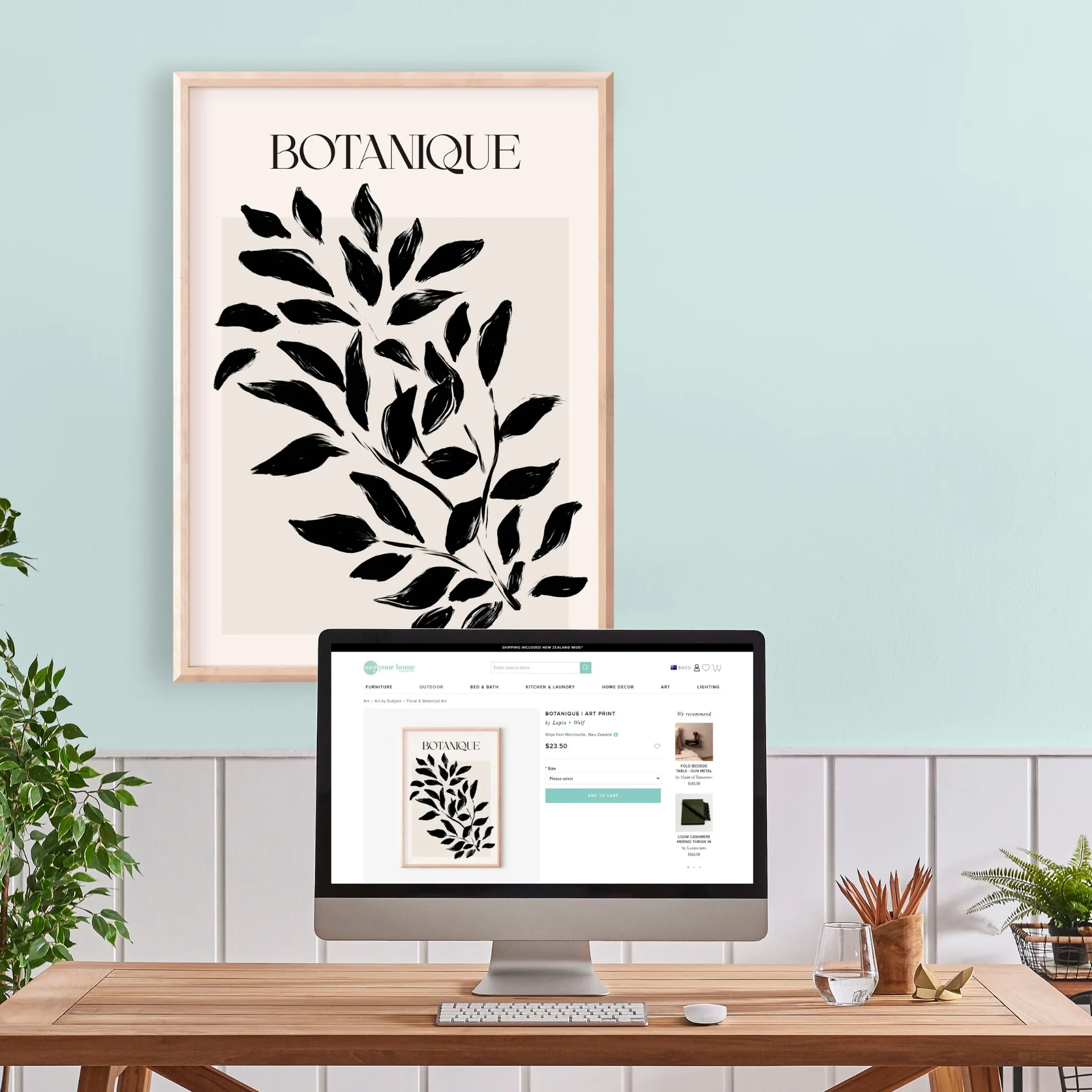 Alt text: "Botanique art print with black leaves on wall above a computer displaying the same print."