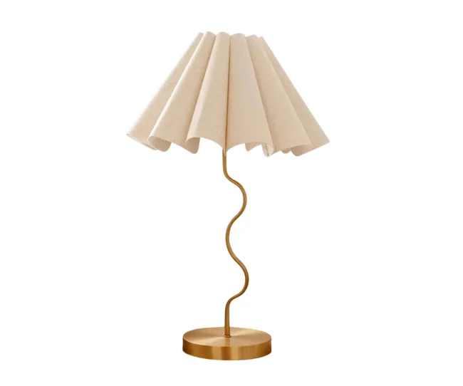 Cream lampshade with a wavy brass base on a round base.