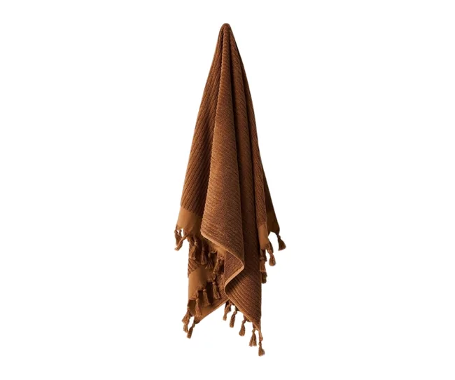 Brown textured blanket with tassels hanging against a white background.