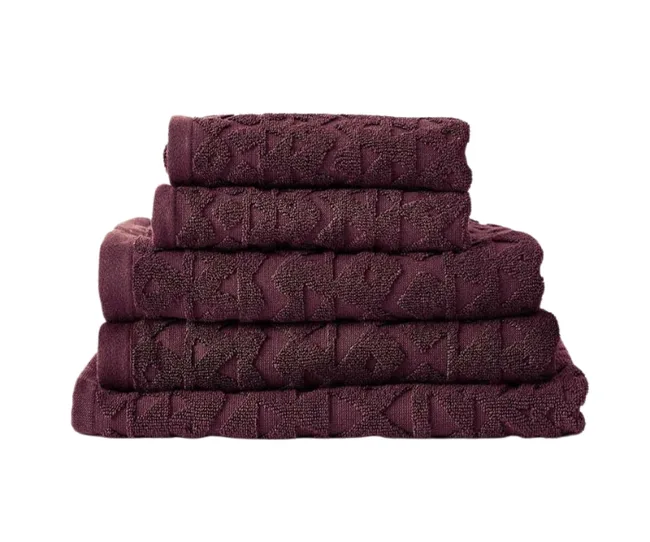 Stack of five dark purple towels with a geometric pattern, neatly folded.
