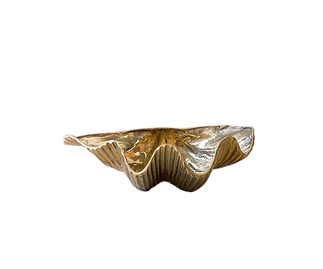 A wavy-edged, gold-colored decorative dish resembling a clam shell on a white background.