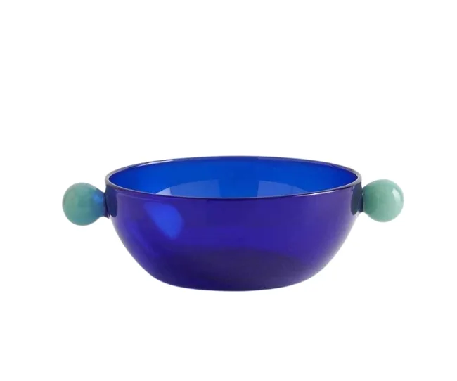 A deep blue glass bowl with two light blue handles on each side.