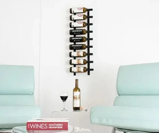 Wall-mounted wine rack with bottles, two chairs, a glass of wine, a bottle on table, and a book titled "Wines."
