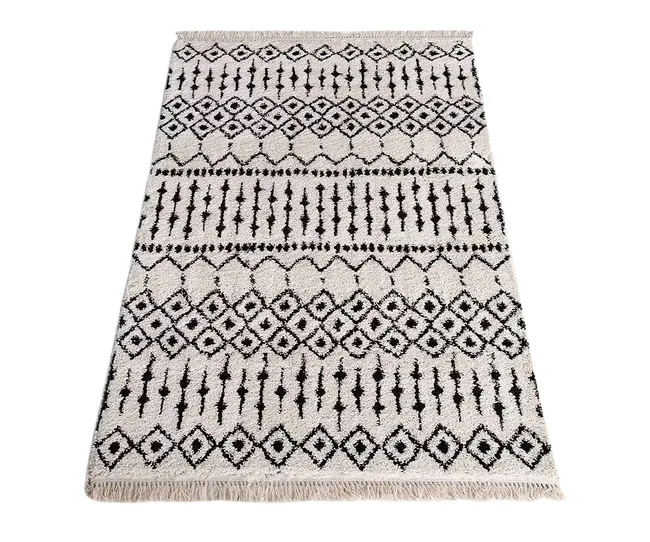 Cream and black patterned area rug with geometric diamond and line designs, featuring fringe on the shorter edges.