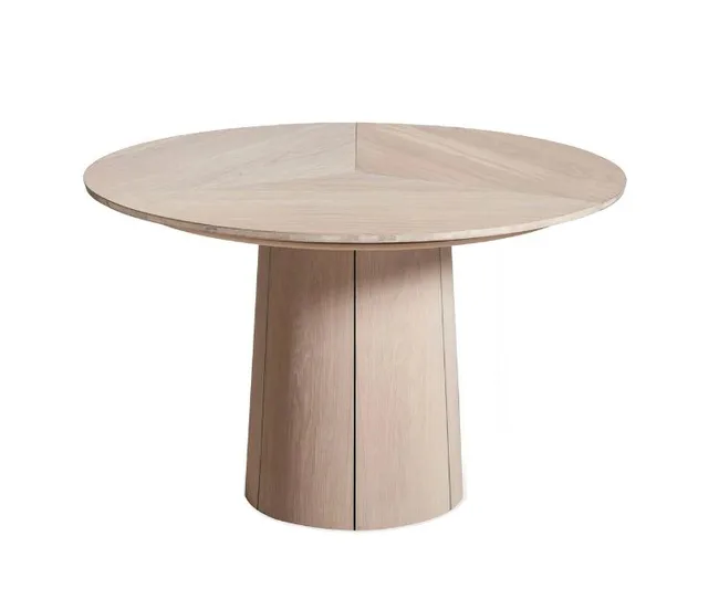 Round wooden dining table with tapered pedestal base and light natural finish.