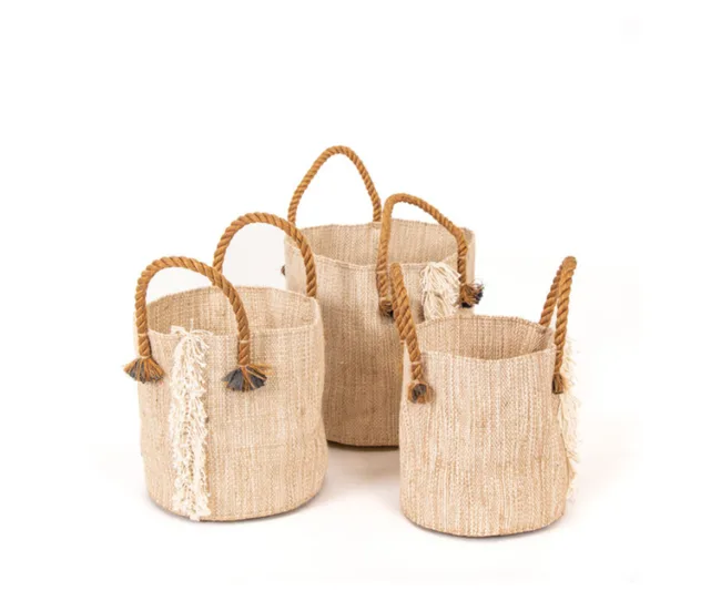 Three woven storage baskets with rope handles and decorative tassels on a white background.