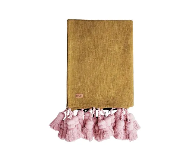 A yellow throw with pink tassels on one edge, folded neatly.