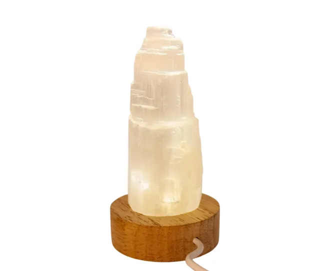 Selenite crystal lamp on wooden base with a soft white glow.