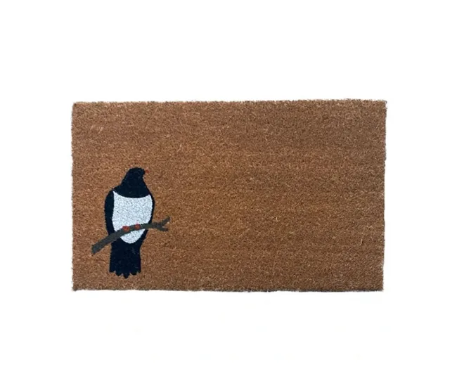 A brown doormat featuring a black and white bird perched on a twig in the corner.