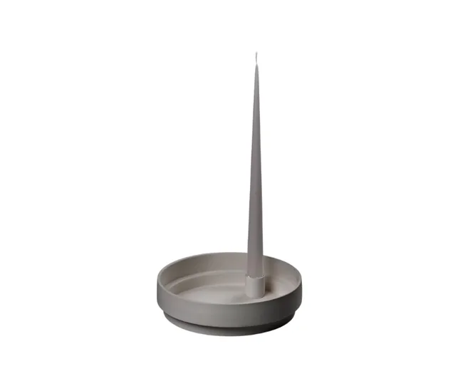 Gray tapered candle on a matching round holder against a white background.