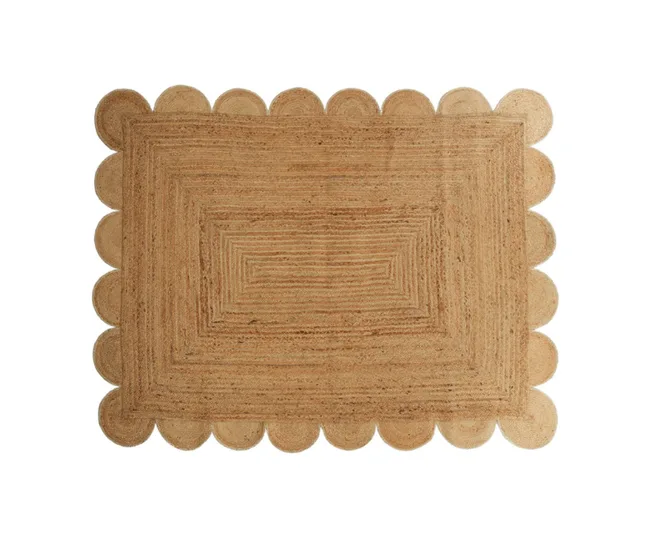 Rectangular natural fiber doormat with scalloped edges.