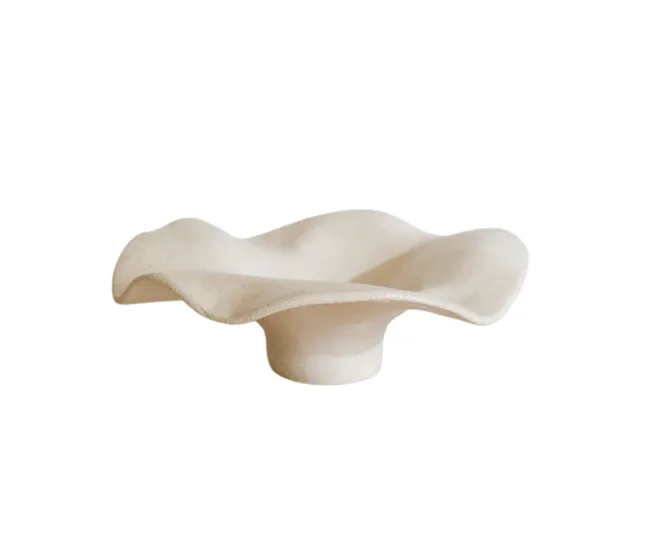 Wavy beige ceramic bowl on a white background.