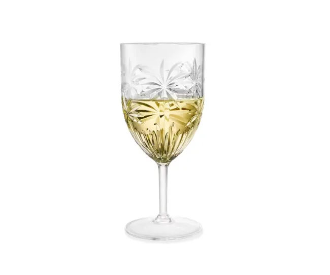 A crystal wine glass with etched patterns, half-filled with white wine.