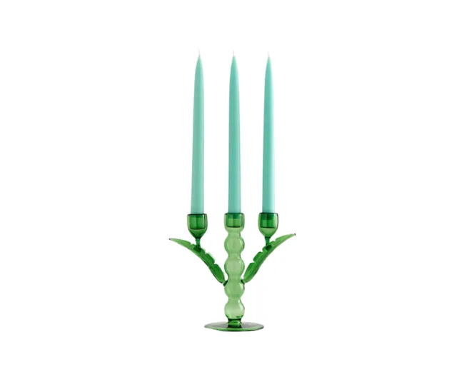 Green glass candelabra with three light blue candles on white background.