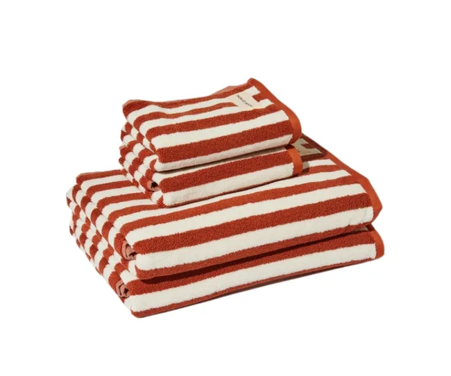 Stack of rust and white striped towels in various sizes on a white background.