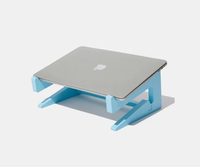 A silver laptop with an Apple logo on a blue stand against a white background.