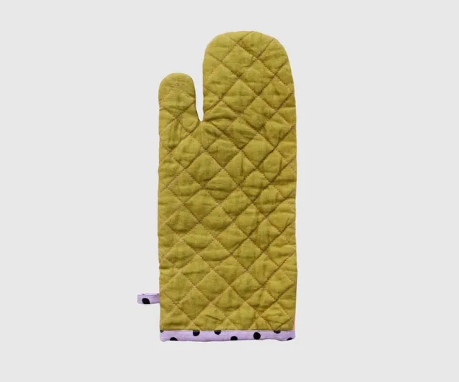 Green quilted oven mitt with a purple polka-dotted trim on a plain white background.