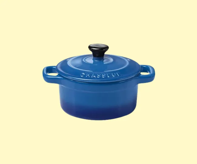 A small blue Le Creuset casserole dish on a yellow background