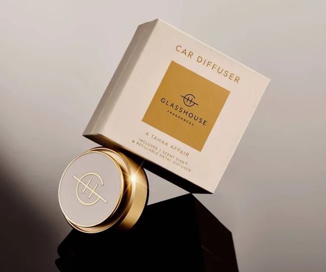 A glasshouse diffuser with a gold rim on a grey background