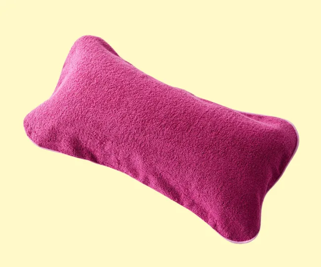 a dark pink beach pillow against a yellow background