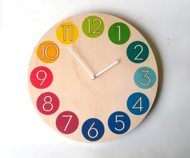 A round wooden clock with colorful numbers from 1 to 12 and white hour and minute hands.