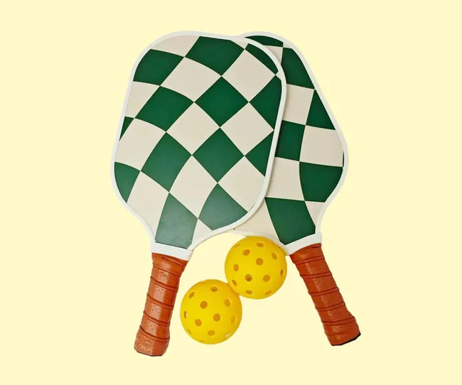 Green and beige pickball bats on a yellow background