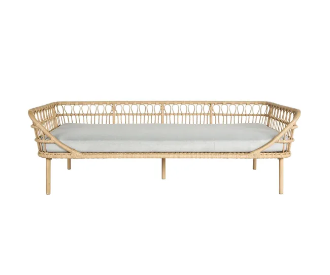 Rattan daybed with a light cushion, featuring an open weave design and simple wooden legs.