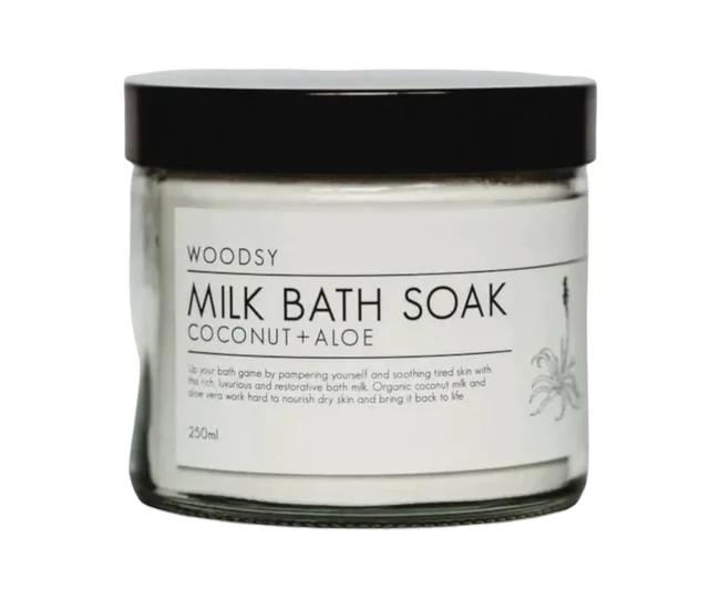 Woodsy Milk Bath Soak jar with coconut and aloe, 250ml, featuring a black lid and white label with floral design.