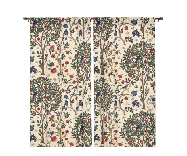 Curtains with intricate tree, bird, and floral patterns in red, blue, and green on a cream background.