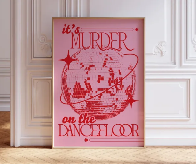 Framed pink poster with red disco ball and text "It's Murder on the Dancefloor" in stylish room.