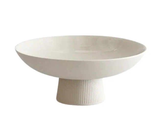 A white ceramic pedestal bowl with a ribbed base.