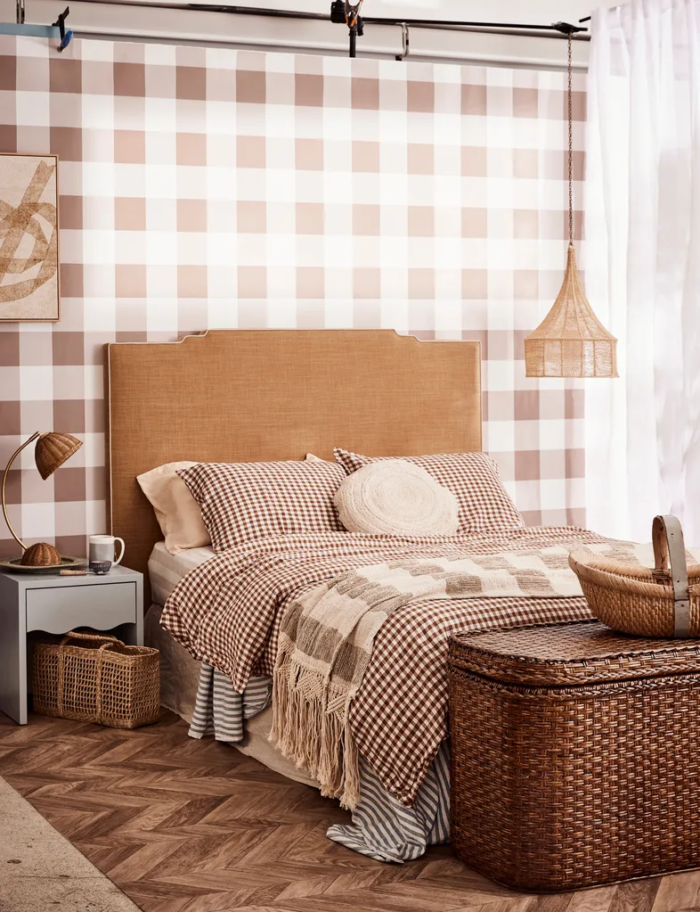 Cozy bedroom with checkered bedding, wicker accents, and neutral tones creating a warm, inviting ambiance.
