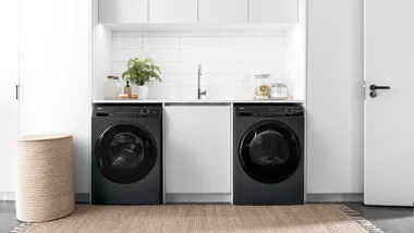 White laundry room with black appliances