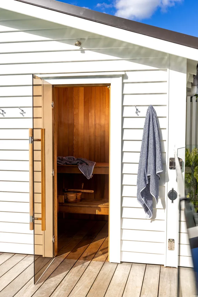 A sauna with a white painted pool house.