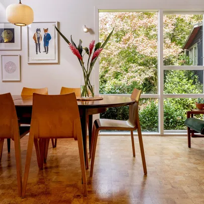 Dining room table with wooden chairs around it and a vase in the middle