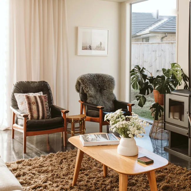 The lounge of a Taranaki home with black leather arm chairs