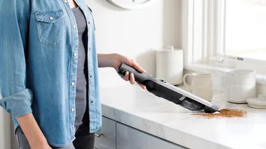 Lady cleaning using the Shark WandVac Handheld vacuum cleaner