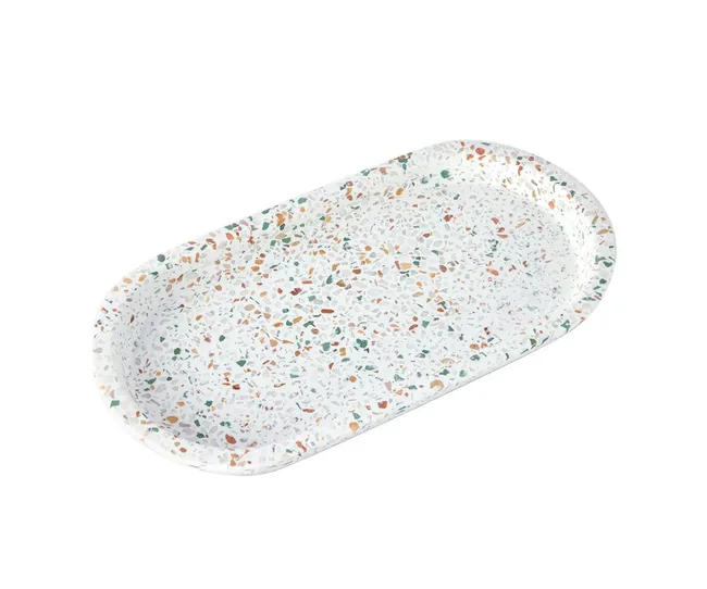 Oval terrazzo tray with multicolored specks on a white background.