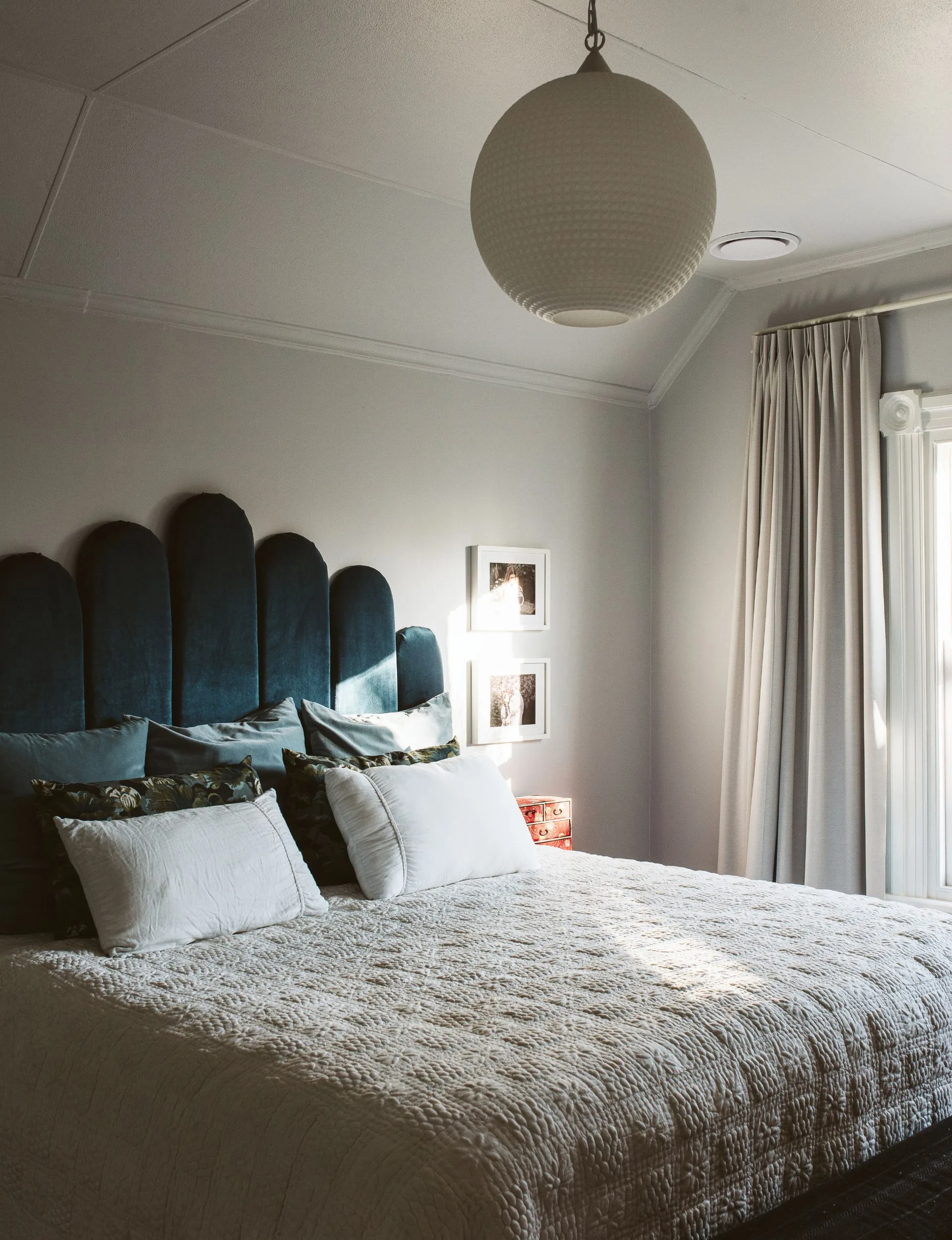 The New Plymouth villa master bedroom with a large green scalloped headboard